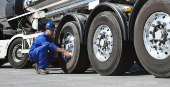 Tire technition working on large semi truck tire 