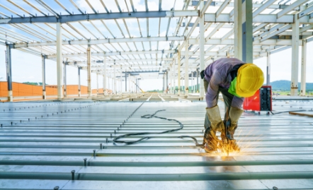 Construction worker welding metal floor joists