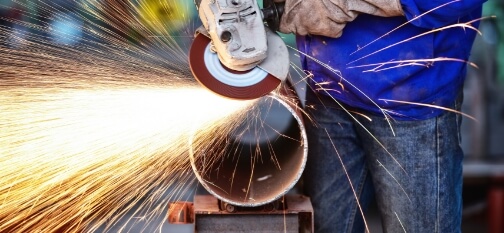 Man grinding metal pipe